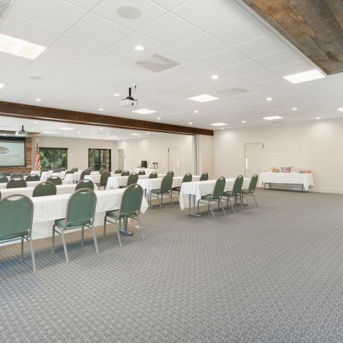 A bright, airy store with checkout counters along the left and a long aisle, shoppers browsing products and white walls.